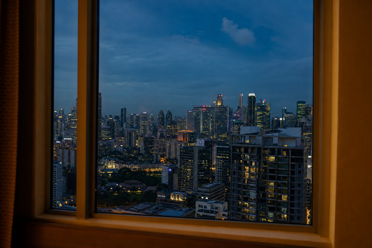 Singapore city skyline with lights coming on at dusk seen from a high window